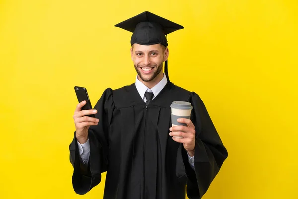Junger Universitätsabsolvent Kaukasischer Mann Isoliert Auf Gelbem Hintergrund Mit Kaffee — Stockfoto