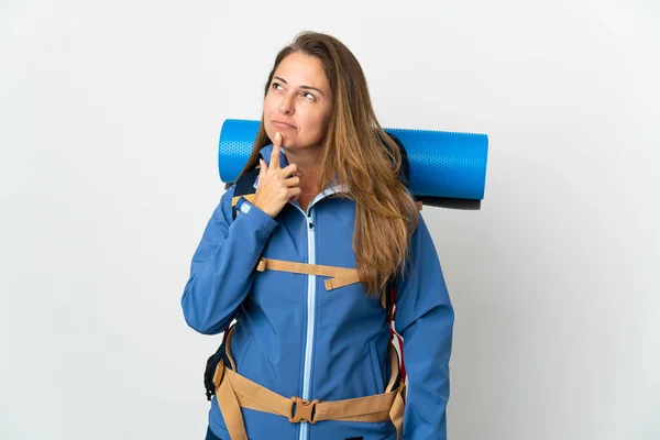 Женщина Альпинистка Средних Лет Большим Рюкзаком Изолированном Фоне Сомневается Глядя — стоковое фото