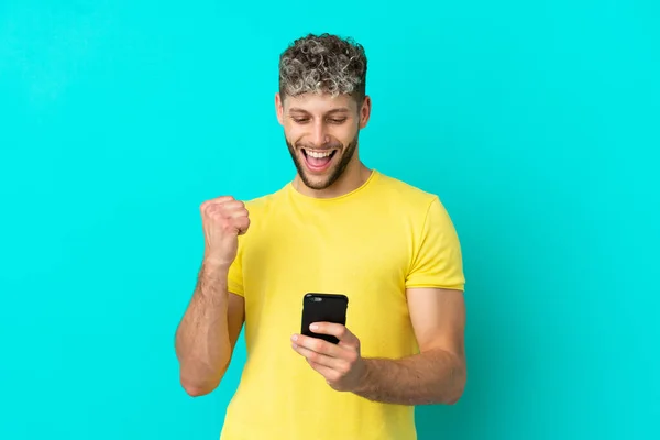 Young Handsome Caucasian Man Isolated Blue Background Phone Victory Position — Stock Photo, Image