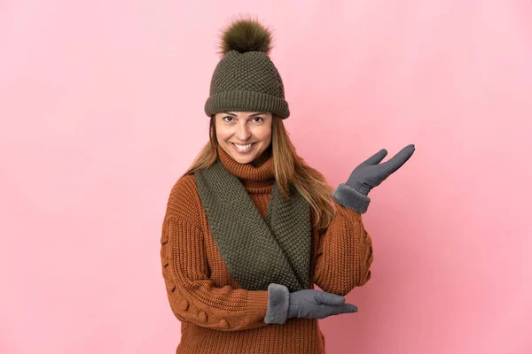 Donna Mezza Età Con Cappello Invernale Isolato Sfondo Rosa Allungando — Foto Stock