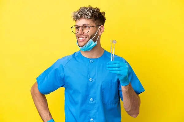 Dentista Caucasiano Homem Segurando Ferramentas Isoladas Fundo Amarelo Posando Com — Fotografia de Stock