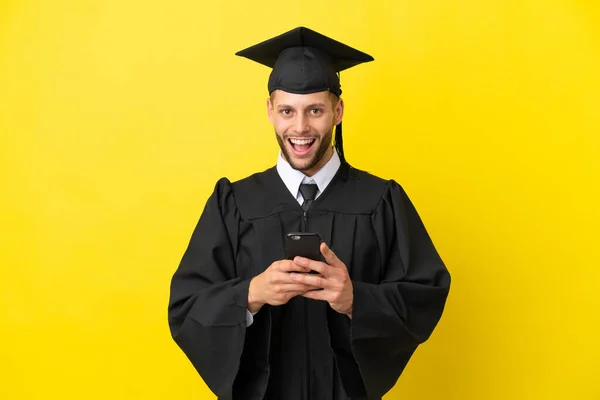 Junger Universitätsabsolvent Kaukasischer Mann Isoliert Auf Gelbem Hintergrund Überrascht Und — Stockfoto