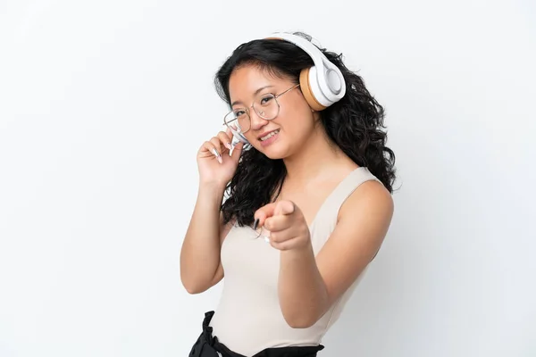 Young Asian Woman Isolated White Background Listening Music Pointing Front — Stock Photo, Image