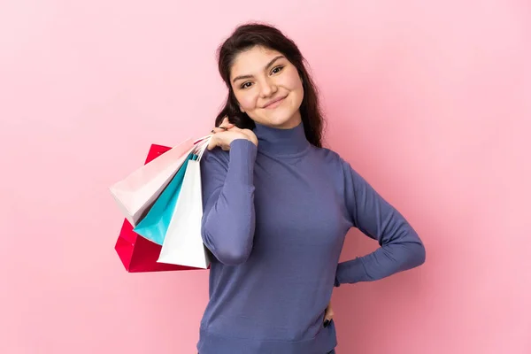 俄罗斯少女孤身一人 背景粉红 提着购物袋 面带微笑 — 图库照片