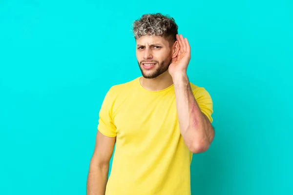 Joven Guapo Hombre Caucásico Aislado Sobre Fondo Azul Escuchando Algo — Foto de Stock