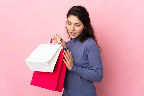 ティーンロシア人女の子隔離上のピンクの背景保持ショッピングバッグ — ストック写真