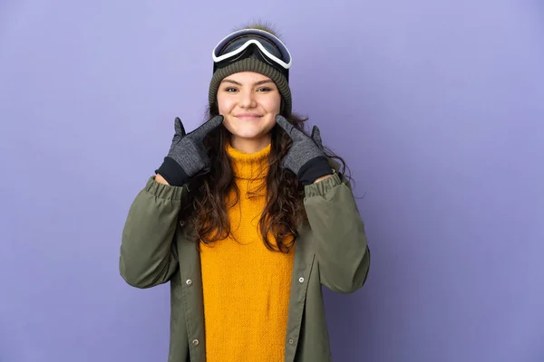俄罗斯少女 戴着雪板眼镜 紫色背景隔离 竖起大拇指 — 图库照片