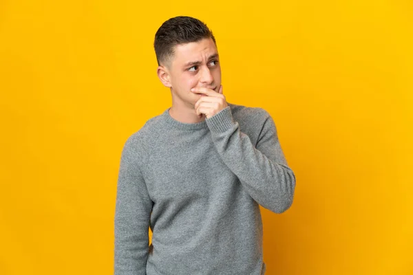 Young Caucasian Man Isolated Yellow Background Having Doubts Confuse Face — Stock Photo, Image