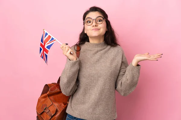 Молодая Россиянка Держащая Флаг Великобритании Розовом Фоне Испытывает Сомнения Поднимая — стоковое фото