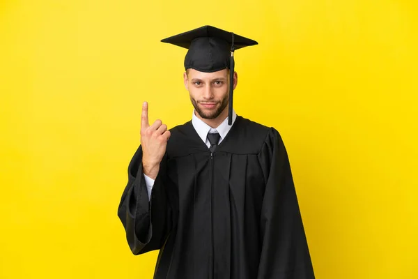 Jonge Afgestudeerde Blanke Man Geïsoleerd Gele Achtergrond Wijzen Met Wijsvinger — Stockfoto