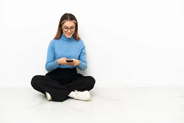 Junge Kaukasierin Sitzt Auf Dem Boden Und Sendet Eine Nachricht — Stockfoto