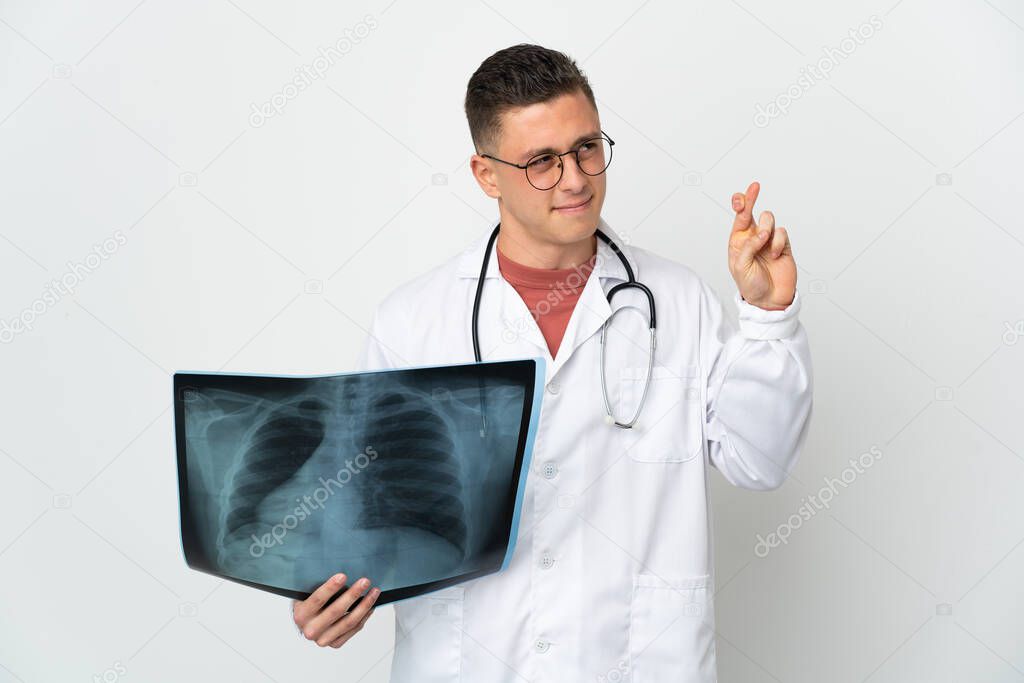 Professional traumatologist on white background with fingers crossing and wishing the best