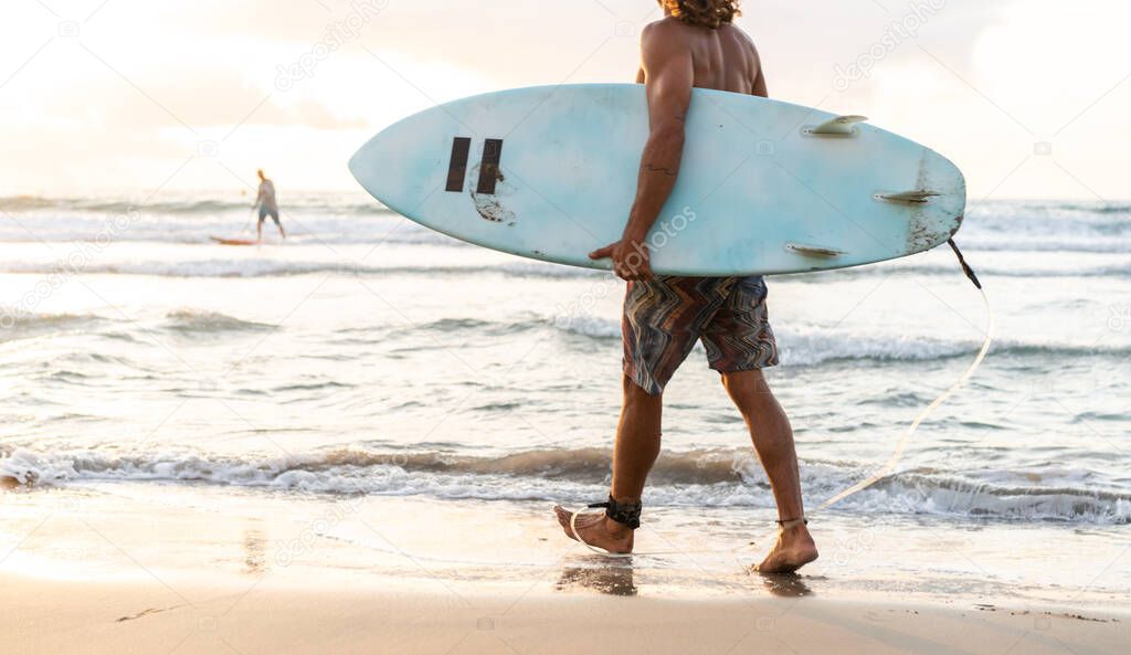 Young caucasian man get up early to  doing surf at sunrise