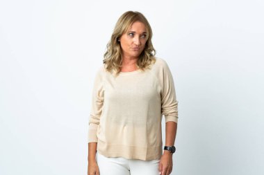 Orta yaşlı sarışın kadın, soyutlanmış beyaz arka planda. Taraf ararken şüphe duyuyor.