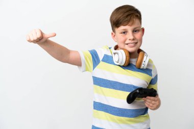 Küçük kızıl saçlı çocuk beyaz arka planda izole edilmiş bir oyun tahtası tutuyor ve baş parmak işareti yapıyor.