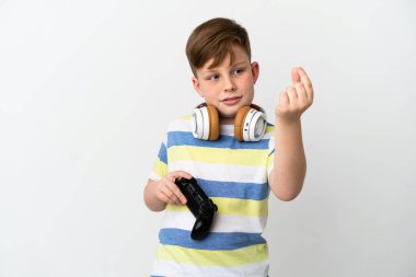 Küçük kızıl saçlı çocuk beyaz arka planda izole edilmiş bir oyun alanı tutuyor ve para hareketi yapıyor.