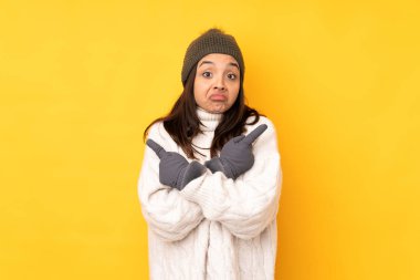 Sarı arka planda, kışlık şapkalı genç bir kadın. Yan taraftakilerin kuşkuları olduğunu gösteriyor.