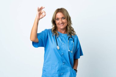 İzole edilmiş arka planda orta yaşlı cerrah kadın parmaklarıyla tamam işareti gösteriyor.