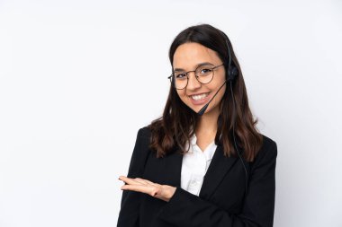 Beyaz arka planda izole edilmiş genç bir pazarlamacı kadın bir fikir sunuyor ve gülümsüyor.