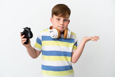 Küçük kızıl saçlı çocuk beyaz arka planda izole edilmiş bir oyun sahası tutuyor.