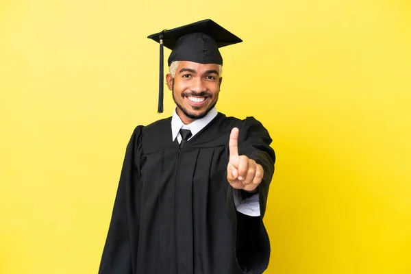 Junger Universitätsabsolvent Kolumbianischer Mann Isoliert Auf Gelbem Hintergrund Zeigt Und — Stockfoto