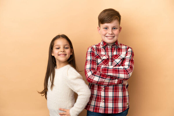 Маленький белый брат и сестра изолированы на бежевом фоне