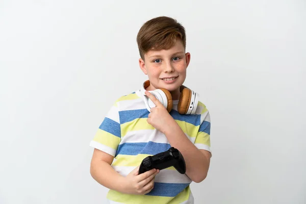 一个红头发的小男孩拿着一个白色背景的游戏垫 指着旁边展示一个产品 — 图库照片