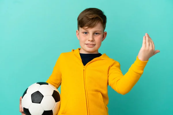 Kleine Roodharige Jongen Geïsoleerd Blauwe Achtergrond Met Voetbal Komende Gebaar — Stockfoto