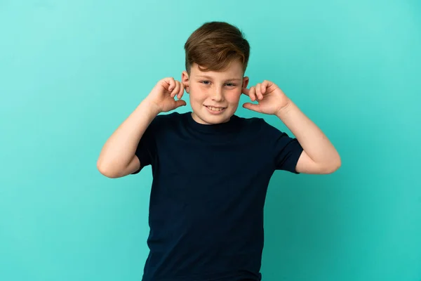 Μικρό Κοκκινομάλλικο Αγόρι Απομονωμένο Μπλε Φόντο Απογοητευμένο Και Καλύπτει Αυτιά — Φωτογραφία Αρχείου