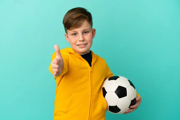 Roodharige Kind Spelen Voetbal Geïsoleerd Blauwe Achtergrond Schudden Handen Voor — Stockfoto