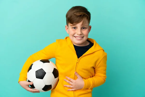 Roodharige Kind Spelen Voetbal Geïsoleerd Blauwe Achtergrond Glimlachen Veel — Stockfoto