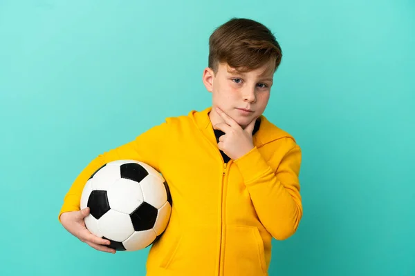 Roodharige Kind Spelen Voetbal Geïsoleerd Blauwe Achtergrond Denken — Stockfoto