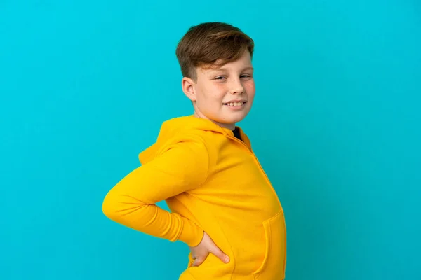 Liten Rödhårig Pojke Isolerad Blå Bakgrund Lider Ryggvärk För Att — Stockfoto