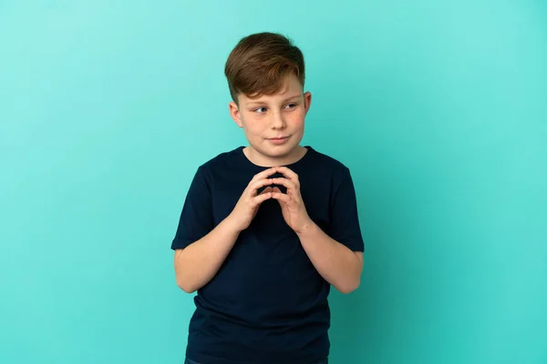 Pequeño Pelirrojo Aislado Sobre Fondo Azul Maquinando Algo —  Fotos de Stock