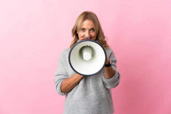 Middelaldrende Blond Kvinne Med Isolert Rosa Bakgrunn Som Roper Gjennom – stockfoto