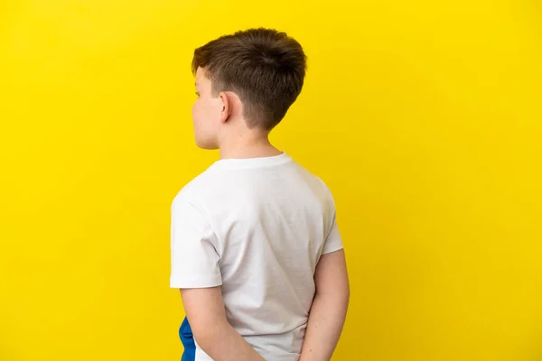 Pequeño Pelirrojo Aislado Sobre Fondo Amarillo Posición Trasera Mirando Hacia — Foto de Stock