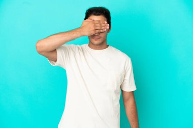 Caucasian handsome man over isolated blue background covering eyes by hands. Do not want to see something