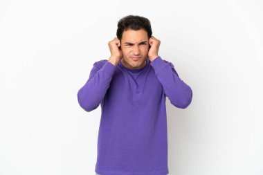 Kafkas yakışıklı adam izole edilmiş beyaz arka planda hayal kırıklığına uğramış ve kulaklarını kapatmış.