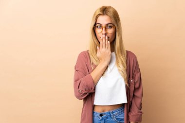 Genç Uruguaylı sarışın kadın izole arka planda ağız ve elleri kapalı