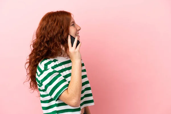 Nastoletnia Ruda Dziewczyna Odizolowanym Różowym Tle Prowadzenie Rozmowy Telefon Komórkowy — Zdjęcie stockowe