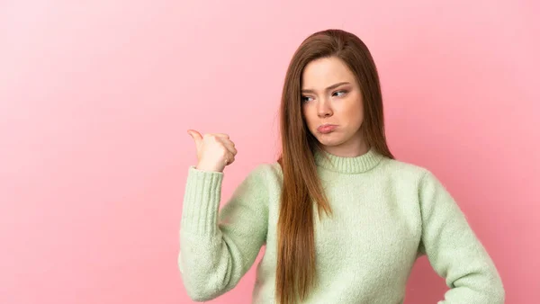 Adolescente Chica Sobre Aislado Rosa Fondo Infeliz Señalando Lado — Foto de Stock