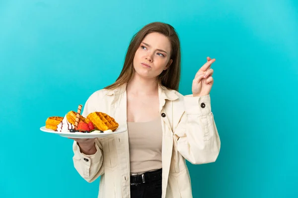 Adolescente Menina Segurando Waffles Sobre Fundo Azul Isolado Com Dedos — Fotografia de Stock