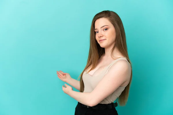 Adolescente Menina Sobre Isolado Fundo Azul Estendendo Mãos Para Lado — Fotografia de Stock