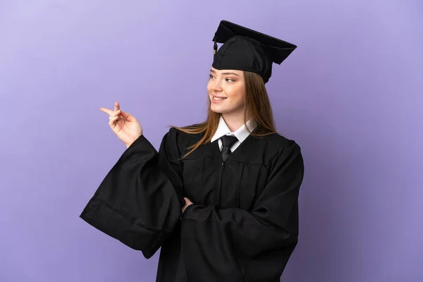 Giovane Laureato Sfondo Viola Isolato Puntando Dito Verso Lato — Foto Stock