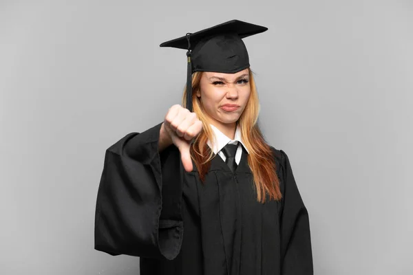 Молодая Выпускница Университета Изолированном Фоне Показывает Большой Палец Вниз Негативным — стоковое фото