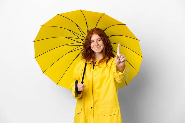 ティーンRedhead女の子レインプルーフコートと傘隔離上の白い背景ショーと持ち上げる指 — ストック写真