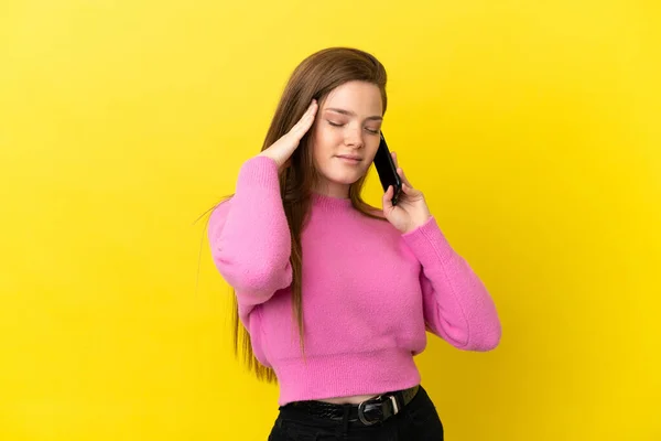 ティーン少女使用携帯電話上の隔離された黄色の背景不満とカバー耳 — ストック写真