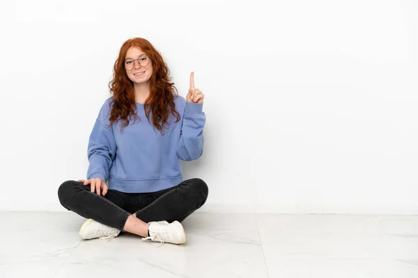 Teenager Zrzka Dívka Sedí Podlaze Izolované Bílém Pozadí Ukazuje Zvedá — Stock fotografie