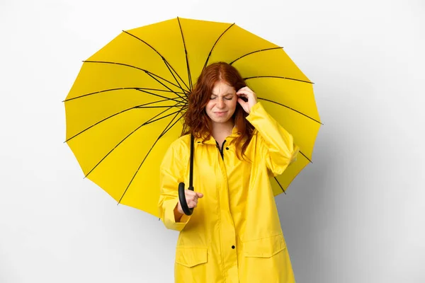 ティーンRedhead女の子雨防止コートと傘隔離上のホワイトバックフラストレーションとカバー耳 — ストック写真