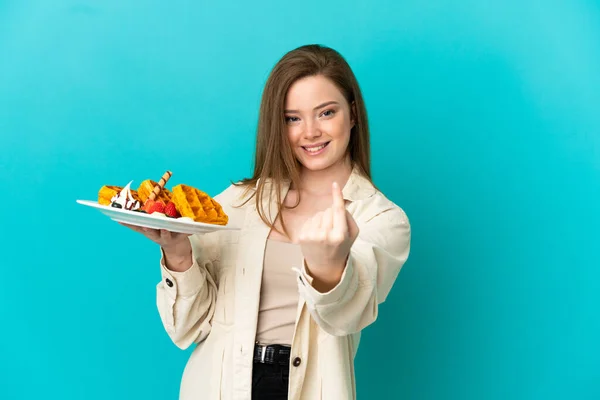 Adolescente Menina Segurando Waffles Sobre Isolado Fundo Azul Fazendo Próximo — Fotografia de Stock